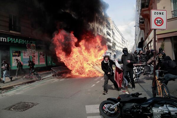 労働者の祭典「メーデー」を記念して行われたデモで、燃える資材の横を歩くデモ隊（フランス・パリ、1日） - Sputnik 日本