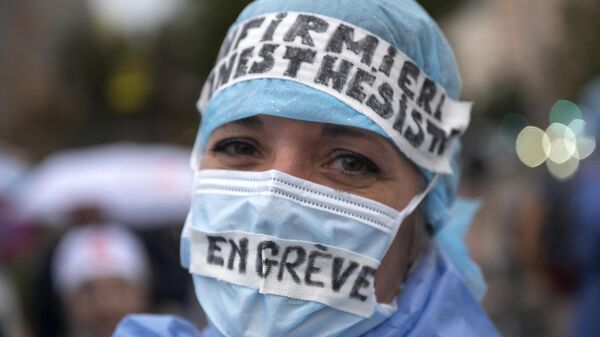 「ストライキ中」と書かれたマスクをつけて、職業の認知度向上と賃上げを訴えるデモに参加する麻酔専門看護師（フランス・マルセイユ、2021年11月25日） - Sputnik 日本