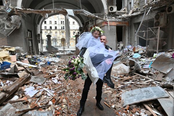 廃墟となったショッピングセンターの中庭で結婚式の記念写真を撮る看護師と医師の夫婦（ウクライナ・ハリコフ、2022年4月3日） - Sputnik 日本