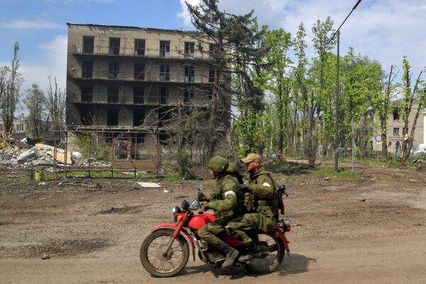 損壊した建物のそばをバイクで走る兵士（ルガンスク人民共和国・ポパスナ、10日） - Sputnik 日本