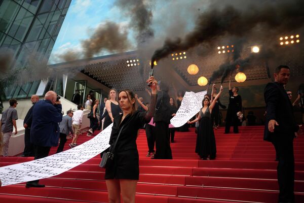 第75回カンヌ国際映画祭で開催された映画『Holy Spider』のプレミアで、フェミサイド（女性殺人）の犠牲になった女性125人の名前が書かれた横断幕を広げる活動家（フランス・カンヌ、22日） - Sputnik 日本