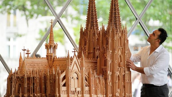 ケルン大聖堂の木彫刻と並んで立つシリア出身のファデル・アルクドゥルさん（ドイツ・ケルン、20日） - Sputnik 日本