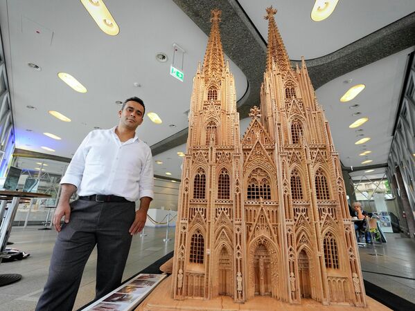 ケルン大聖堂の木彫刻と並んで立つシリア出身のファデル・アルクドゥルさん（ドイツ・ケルン、20日） - Sputnik 日本