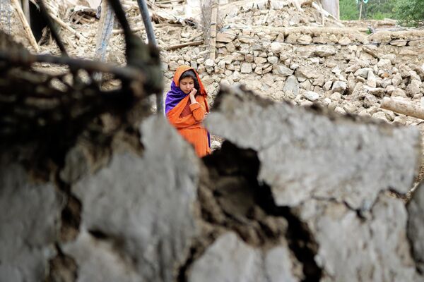 地震で被害を受けた家のそばに立つ少女（アフガニスタン・ホスト州、22日） - Sputnik 日本