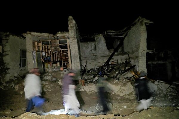 地震で損壊した建物のそばを歩く住民（アフガニスタン・パクティカ州、22日） - Sputnik 日本