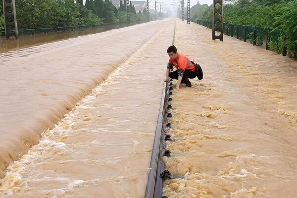 大雨で冠水した線路を点検する鉄道職員（中国・江西省上饒市、21日） - Sputnik 日本