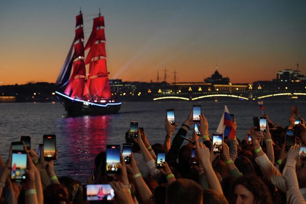 祭り「赤い帆」で、ネヴァ川の川岸から「ブリッグ・ロシア」が通過する様子を撮影する市民（ロシア・サンクトペテルブルク、25日） - Sputnik 日本