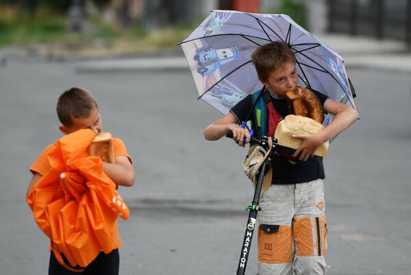 人道支援物資として受け取ったパンを食べる子どもたち（ウクライナ・マリウポリ、27日） - Sputnik 日本