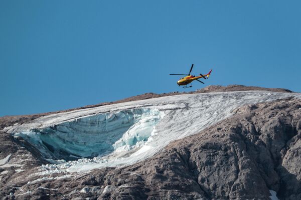 氷河の崩落が発生したマルモラーダ山上空を飛ぶ救助ヘリ（イタリア・マルモラーダ山、4日） - Sputnik 日本