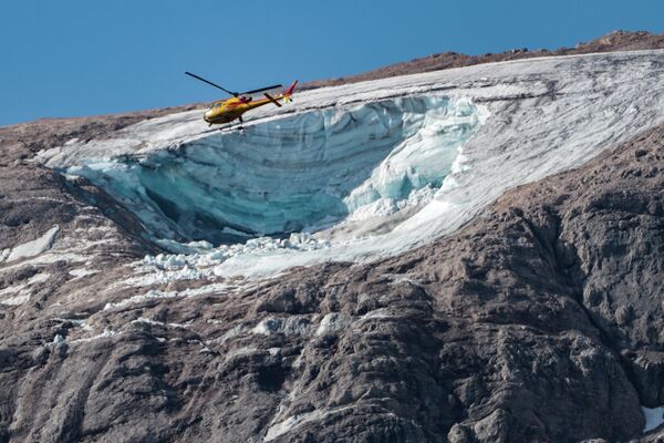 氷河の崩落が発生したマルモラーダ山上空を飛ぶ救助ヘリ（イタリア・マルモラーダ山、4日） - Sputnik 日本