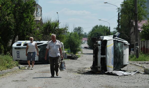 横転した車の横を歩く住民（ルガンスク人民共和国・リシチャンスク、3日） - Sputnik 日本