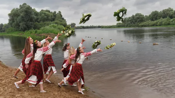 スラブ圏の夏至祭「イワン・クラパの日」に、民族衣装を着て川へ花輪を投げ入れる女性ら（ベラルーシ・パリチ、6日） - Sputnik 日本