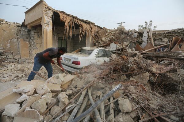 マグニチュード6.0の強い地震が発生した後、瓦礫を片付ける男性（イラン・ホルモズガーン州、2日） - Sputnik 日本