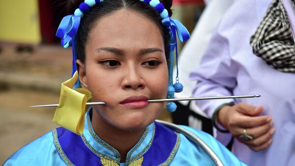 中国系の寺院「ゴウ・レンチー」で行われた恒例のパレードで、頬に串を刺す女性（タイ・ナラティワート県、13日） - Sputnik 日本