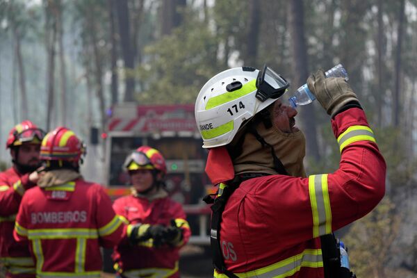 消火活動中、水で目を洗い流す消防隊員（ポルトガル・コルメイアス、13日） - Sputnik 日本