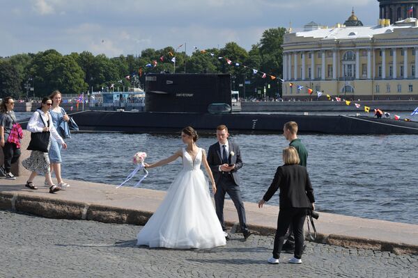 ネヴァ川の川岸に立つ新婚夫婦。後ろは潜水艦B-585「サンクトペテルブルク」（24日） - Sputnik 日本