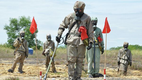 空港で、米国が資金提供する枯葉剤汚染浄化プロジェクトの立ち上げ時に、防護服姿で不発弾と枯葉剤の検出に関するプレゼンテーションを受ける兵士（ベトナム・ダナン） - Sputnik 日本