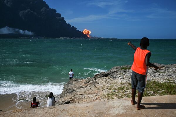 キューバ北部の海岸で、対岸の燃料貯蔵庫の大火災を見詰める市民 - Sputnik 日本