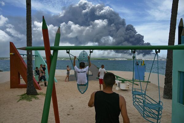 大規模火災が発生した石油施設火災から立ち上る黒煙を眺める人々（キューバ・マタンサス、8日） - Sputnik 日本