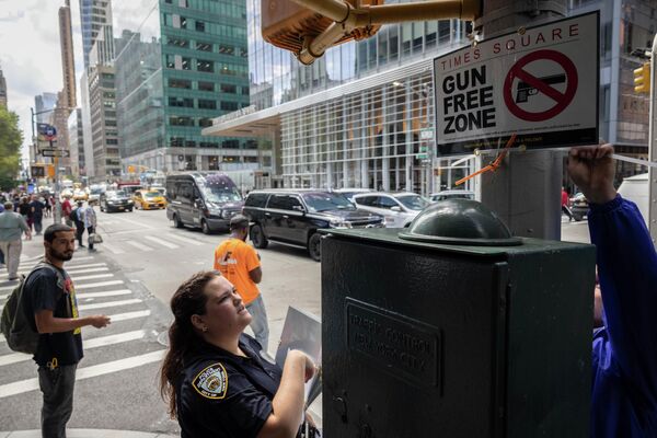 タイムズスクエア周辺に「Gun Free Zone」と書かれた張り紙を張るニューヨーク市警の担当者（米ニューヨーク、31日） - Sputnik 日本