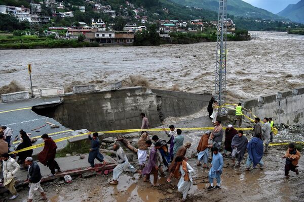 モンスーンによる豪雨の後、洪水の被害を受けた道路の前に集まる人々（パキスタン・マディアン、27日） - Sputnik 日本