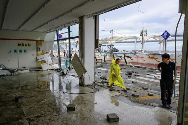 台風で大きな被害を受けた店の前を歩く人々（韓国・釜山、6日） - Sputnik 日本