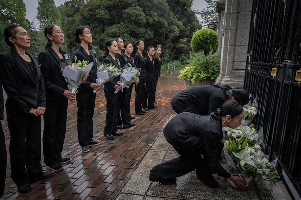 エリザベス女王の死去を受け、駐日英国大使館の外で献花するバレエ団の団員（日本・東京都、9日） - Sputnik 日本