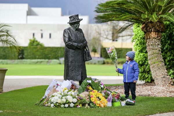 総督官邸の敷地内で、エリザベス女王の像に花を手向ける少年（オーストラリア・アデレード、9日） - Sputnik 日本