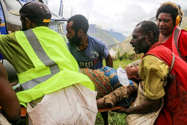 担架に乗せられ、ヘリコプターに運び込まれる村人（パプアニューギニア・モロベ州、11日） - Sputnik 日本