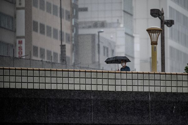 大雨の中、傘をさして街を歩く男性（東京都台東区、18日） - Sputnik 日本
