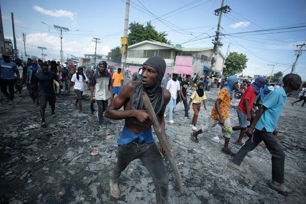 アリエル・アンリ首相の辞任を求める抗議デモで、武器を模した木片を構えるデモ参加者（ハイチ・ポルトープランス、3日） - Sputnik 日本