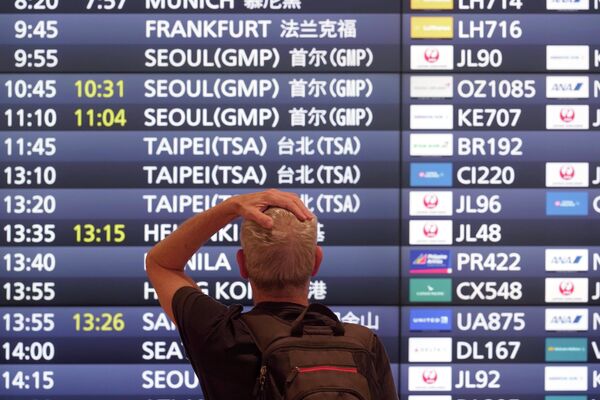 羽田空港で発着案内板を眺める外国人観光客（東京・大田区、11日） - Sputnik 日本
