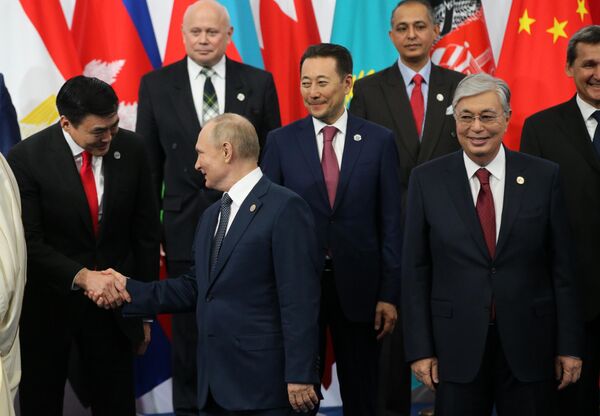 各国首脳との記念撮影で握手を交わすモンゴルのアマルサイハン副首相（左）とロシアのプーチン大統領（カザフスタン・アスタナ、13日） - Sputnik 日本