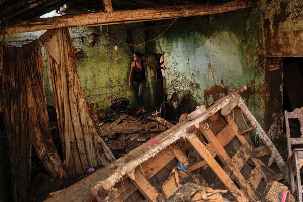 地滑りと洪水の被害を受けた自宅に立つ女性（ベネズエラ・ラス・テヘリアス、10日） - Sputnik 日本