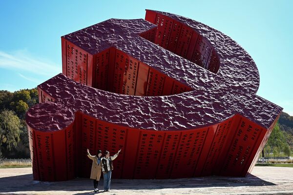 中国共産党第20回党大会の初日、党の記念碑を背景に写真を撮影する人々（中国・陝西省延安市、16日） - Sputnik 日本