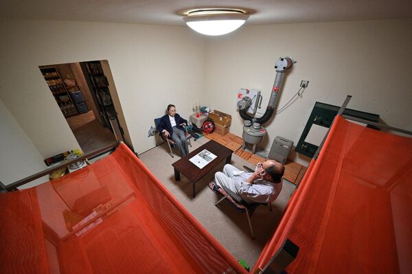 織部精機製作所のモデルハウスに設置された地下核シェルターに社員と座る同社取締役の織部信子さん（兵庫県神戸市、15日） - Sputnik 日本