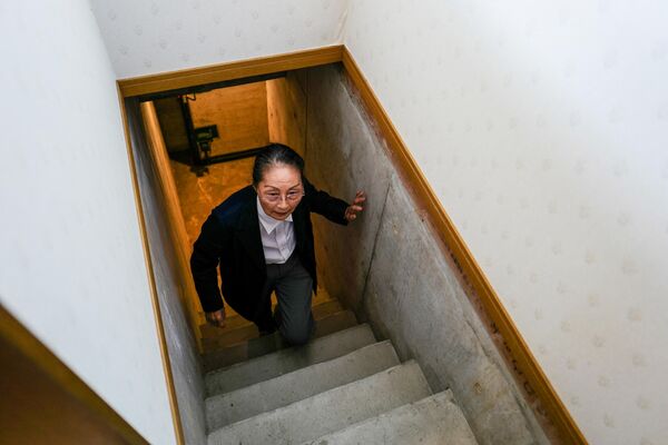 地下核シェルターから外部へ通じる階段を上る織部精機製作所取締役の織部信子さん（兵庫県神戸市、15日） - Sputnik 日本