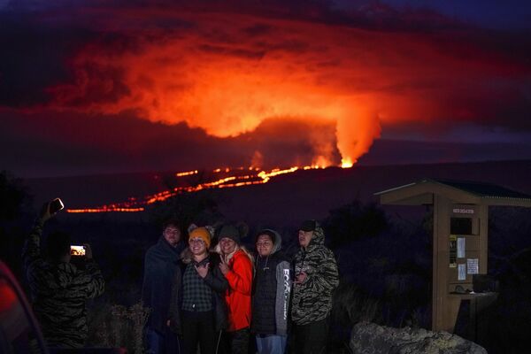 溶岩を噴出するマウナ・ロア火山の前で記念撮影する人々（米ハワイ島、30日） - Sputnik 日本