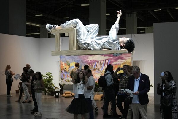 米国最大級のアートフェア「アート・バーゼル・マイアミ・ビーチ」で、アートの一環で椅子に横になるパフォーマー（米フロリダ州・マイアミビーチ、29日） - Sputnik 日本