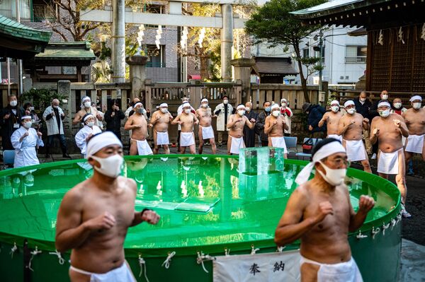 日本の東京都中央区にある鉄砲洲稲荷神社（てっぽうずいなりじんじゃ）行われた新年恒例の寒中水浴大会（寒中みそぎ）。参加者は水槽に入る前に体を温める（写真は1月9日撮影） - Sputnik 日本