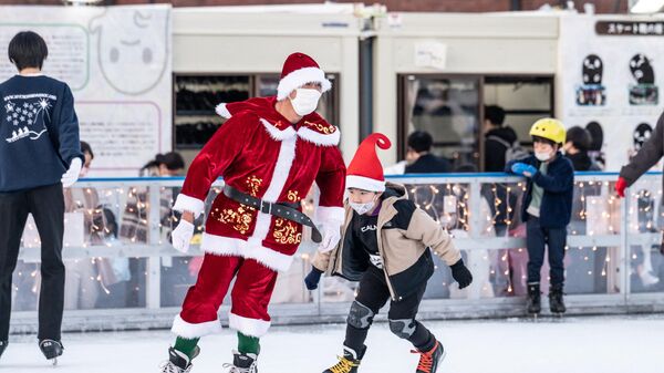サンタ姿で赤レンガ倉庫前のスケートリンクを滑る人（神奈川県横浜市、10日） - Sputnik 日本