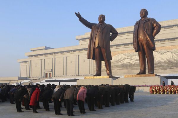 金正日総書記の没後11年を迎え、ピョンヤンにある万寿台記念碑の金日成・金正日両元総書記の銅像の前で頭を下げる人々 - Sputnik 日本