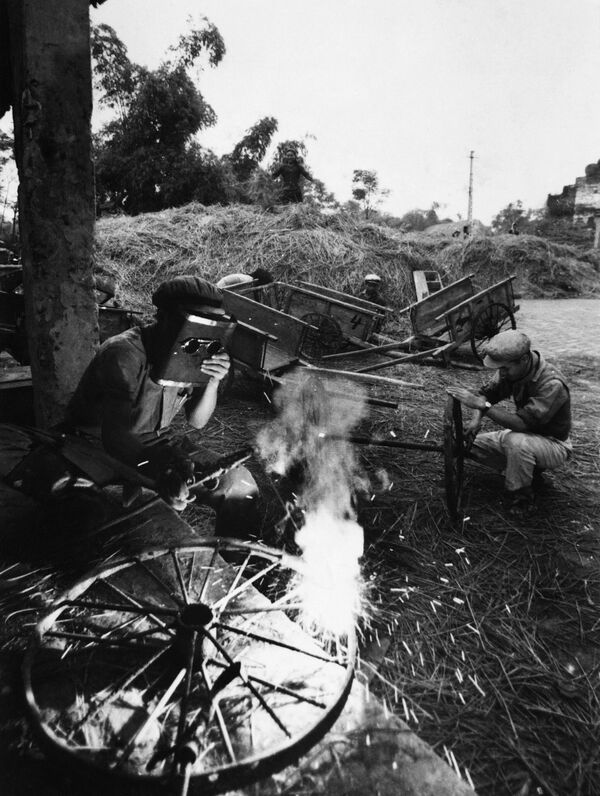 米の運搬用リヤカーの車輪を整備する作業員たち。米軍の砲撃で農機具工場は破壊された。1968年4月、北ベトナムの農村 - Sputnik 日本