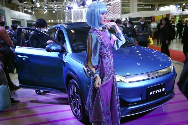 東京オートサロンで、中国の自動車メーカー「BYD」の電気自動車「ATTO 3」の横でポーズをとるモデル - Sputnik 日本