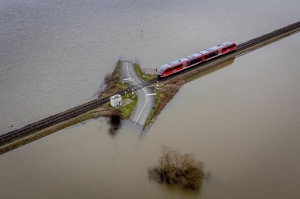 フランクフルト近郊のニーダーアイヒェンで汽車が浸水した草地を通る線路に接近、ドイツ - Sputnik 日本