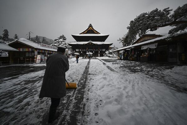 善光寺の境内を雪かきする男性（長野市、25日） - Sputnik 日本