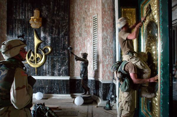バグダッドにあるサダム・フセイン宮殿の正面扉から大統領の装飾を剥がす米軍兵士（2003年4月） - Sputnik 日本