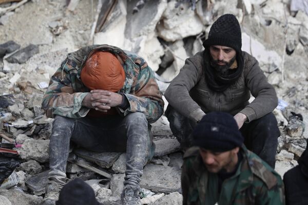 倒壊した建物の瓦礫の上に座る地元住民（シリア・アレッポ、7日） - Sputnik 日本