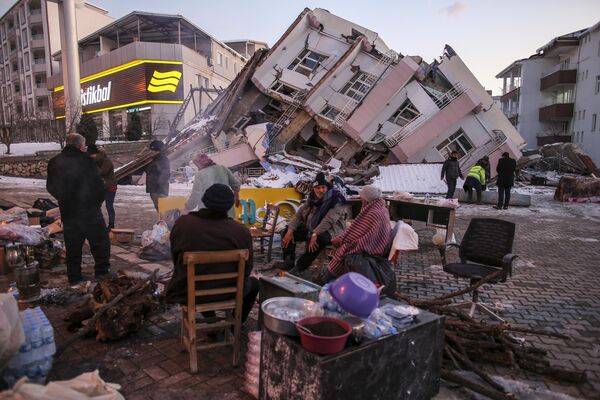 地震で倒壊した建物のそばに立つ人々（トルコ・アドゥヤマン県コルバシ、8日） - Sputnik 日本