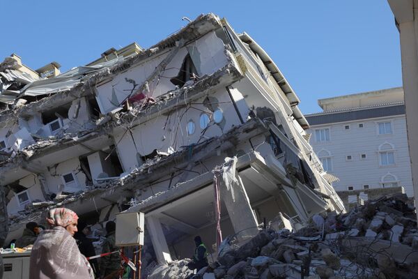 崩壊した建物の前に立つ女性 - Sputnik 日本